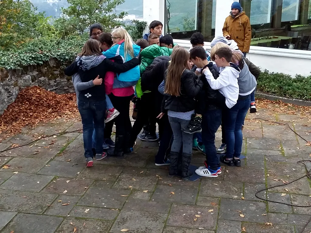 Gruppe steht eng zusammengedrängt im Kreis.